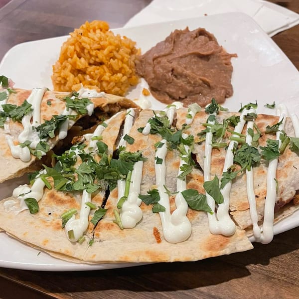 Margarita's Cocina Mexicana quesadilla with rice and refried beans, topped with sour cream and cilantro.