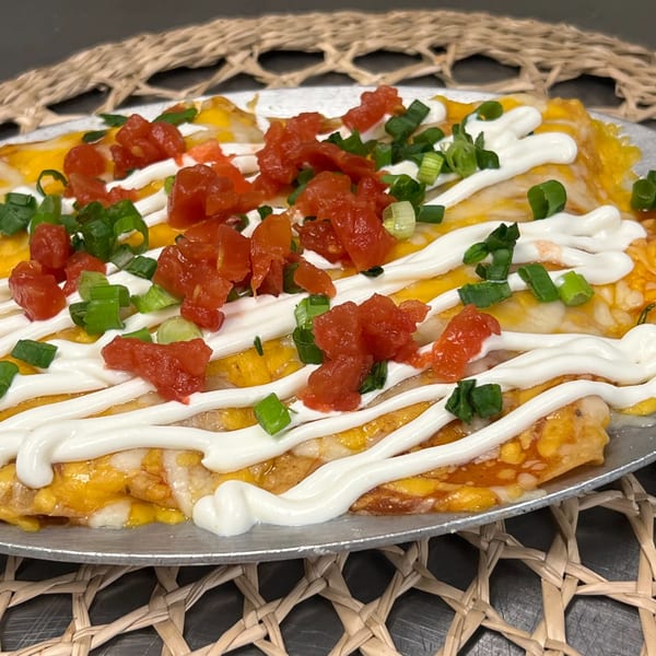 Margarita's Cocina Mexicana's enchiladas topped with melted cheese, sour cream, diced tomatoes, and green onions.